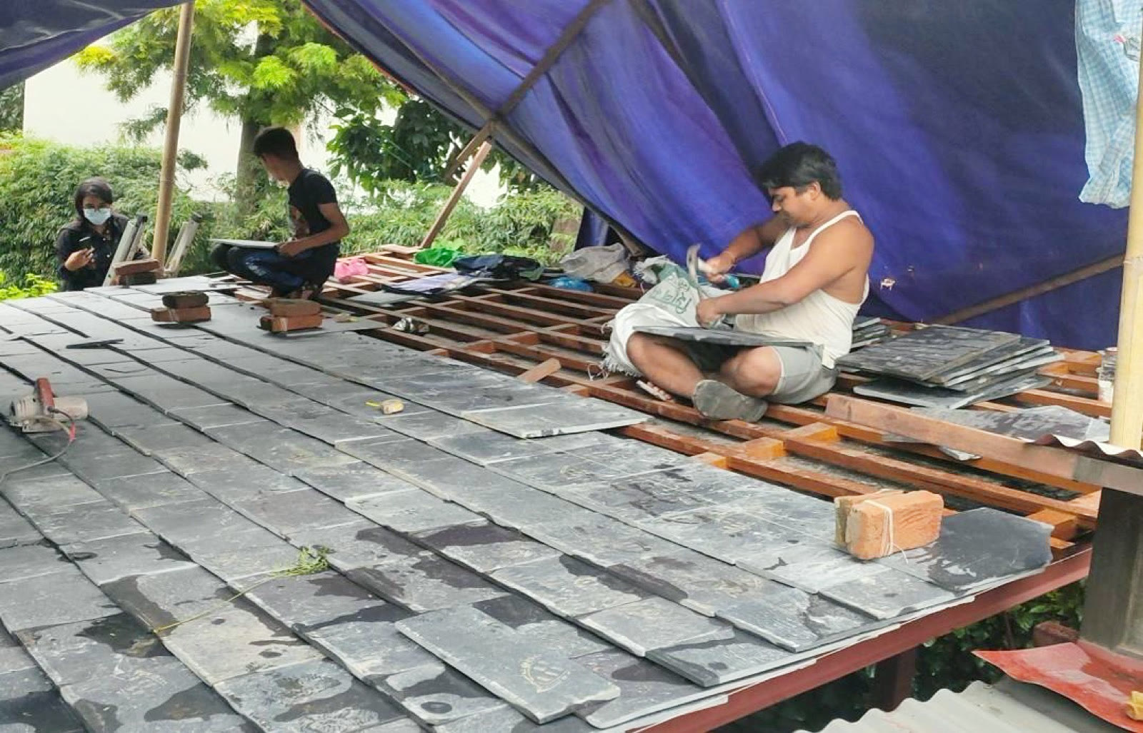 工人以手工鋪設石板瓦屋頂